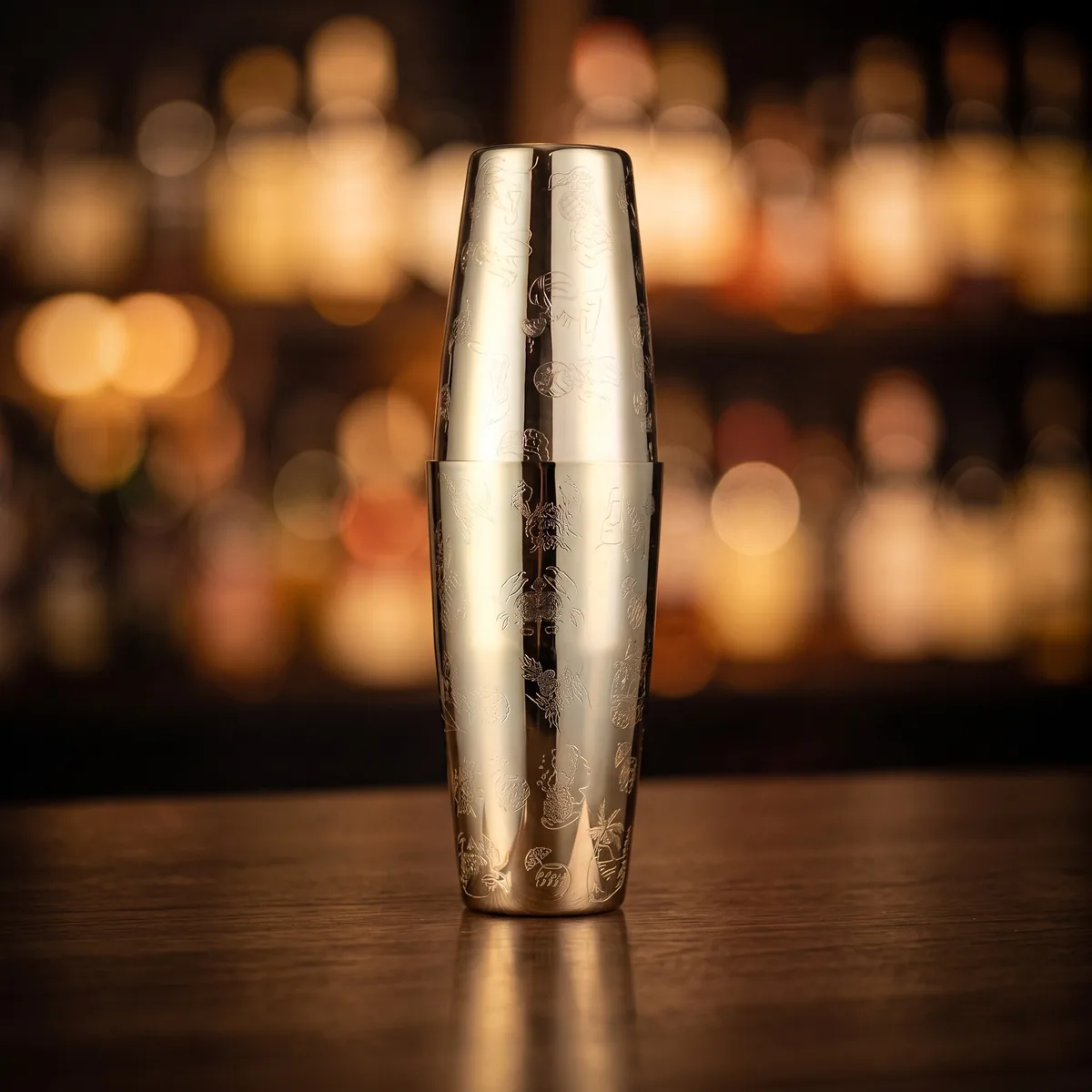 Gold engraved Boston shaker, Hula pattern, on a bar counter