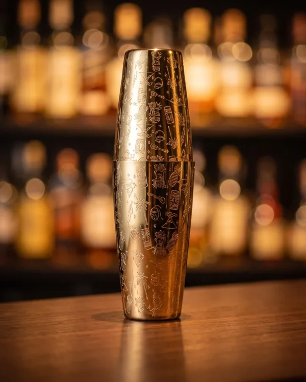 Gold engraved Boston shaker, Tiki pattern, on a bar counter