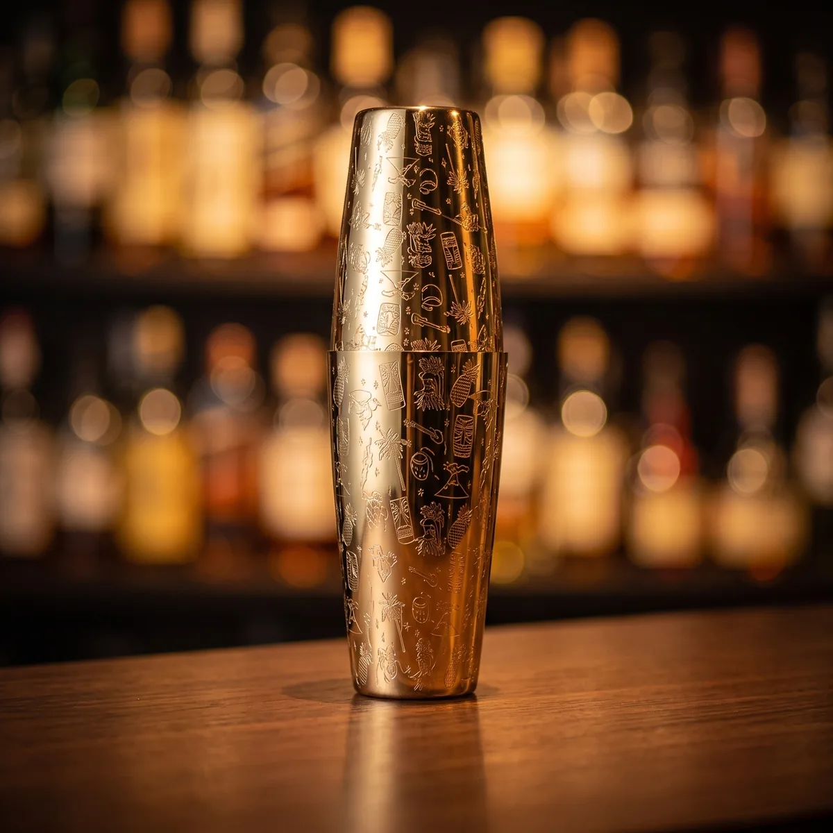 Gold engraved Boston shaker, Tiki pattern, on a bar counter