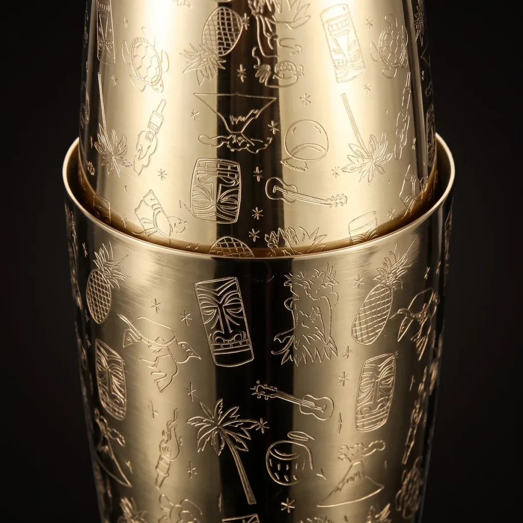 Gold engraved Boston shaker, Tiki pattern, three-quarter view