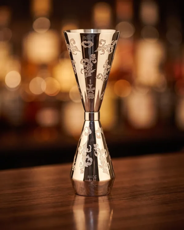 Engraved jigger 30/60 ml, petal pattern, on a bar counter