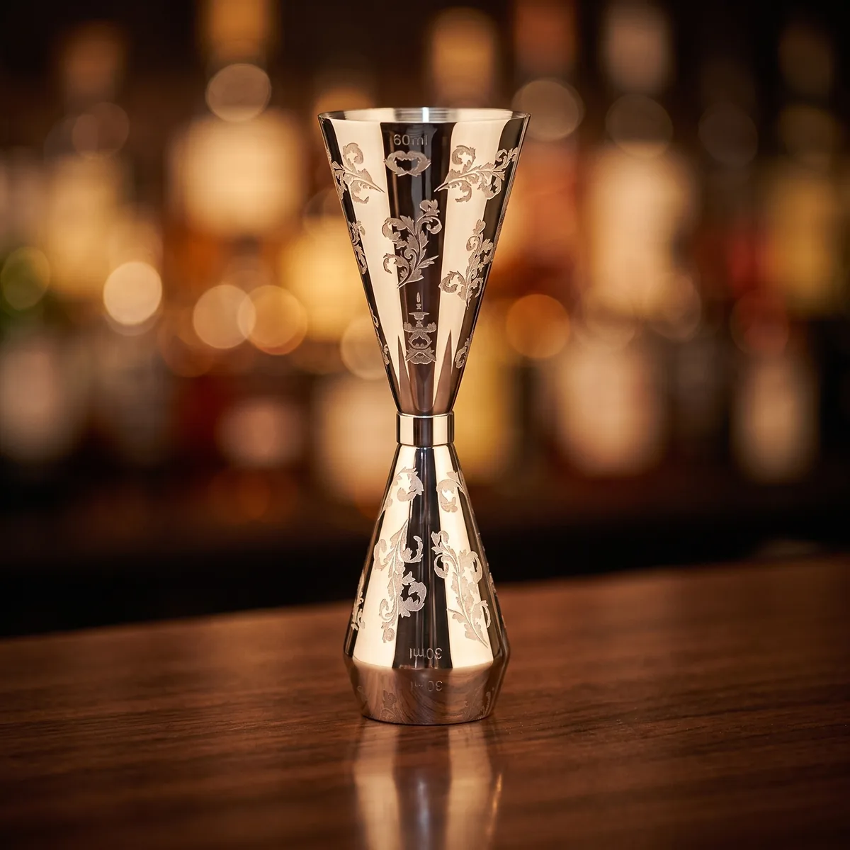 Engraved jigger 30/60 ml, petal pattern, on a bar counter