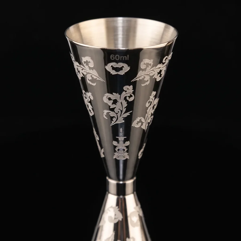 Engraved jigger 30/60 ml, petal pattern, three-quarter view