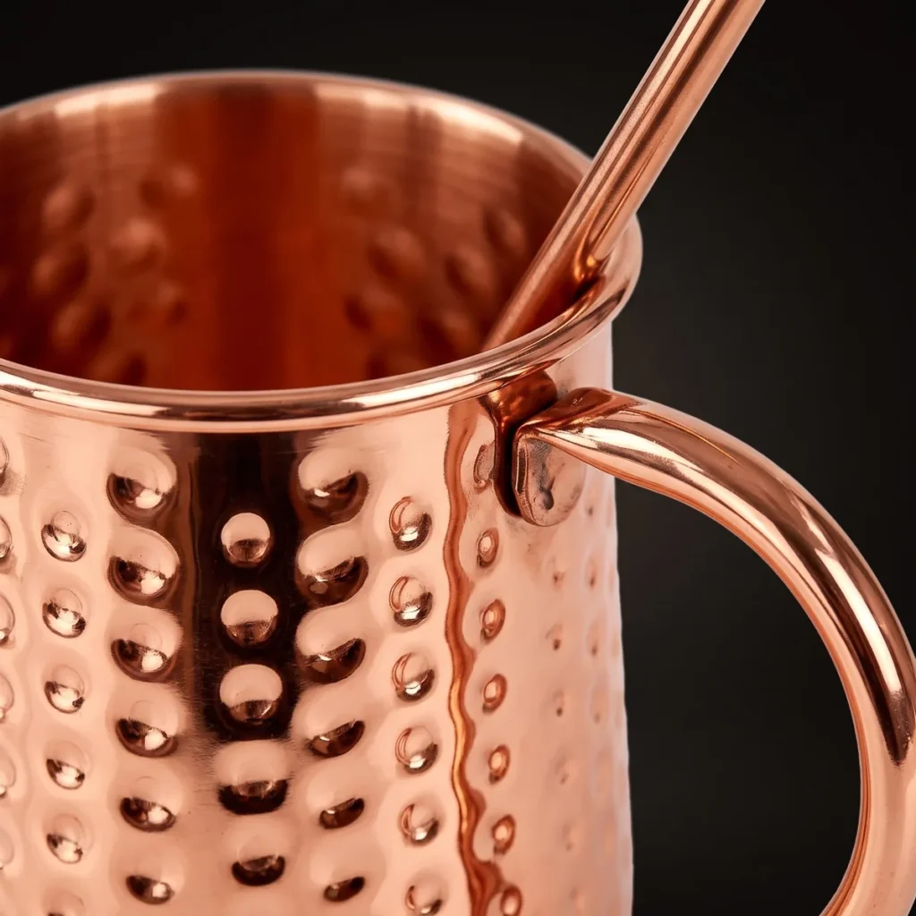 Hammered copper Moscow Mule mug with straw, three-quarter view