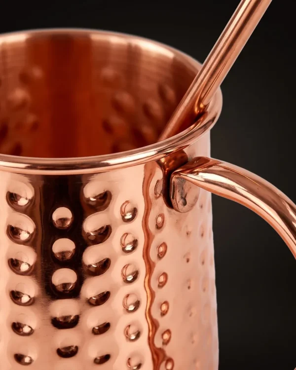 Hammered copper Moscow Mule mug with straw, three-quarter view