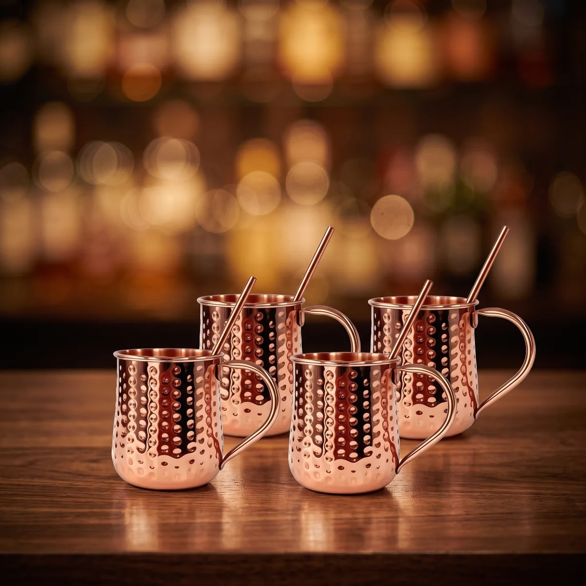 Copper Moscow Mule mugs and straws, set of 4, on a bar counter