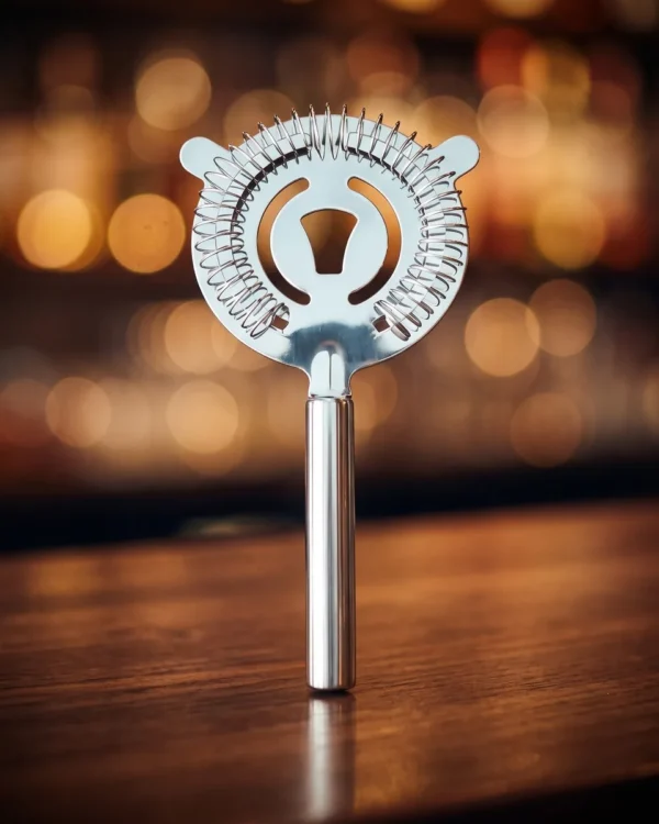 Cat cocktail strainer, long handle, on a bar counter